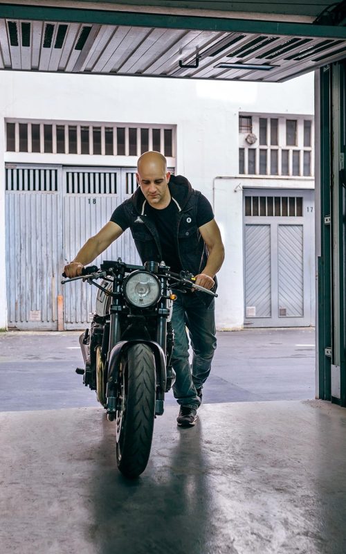 biker-taking-motorbike-to-the-garage